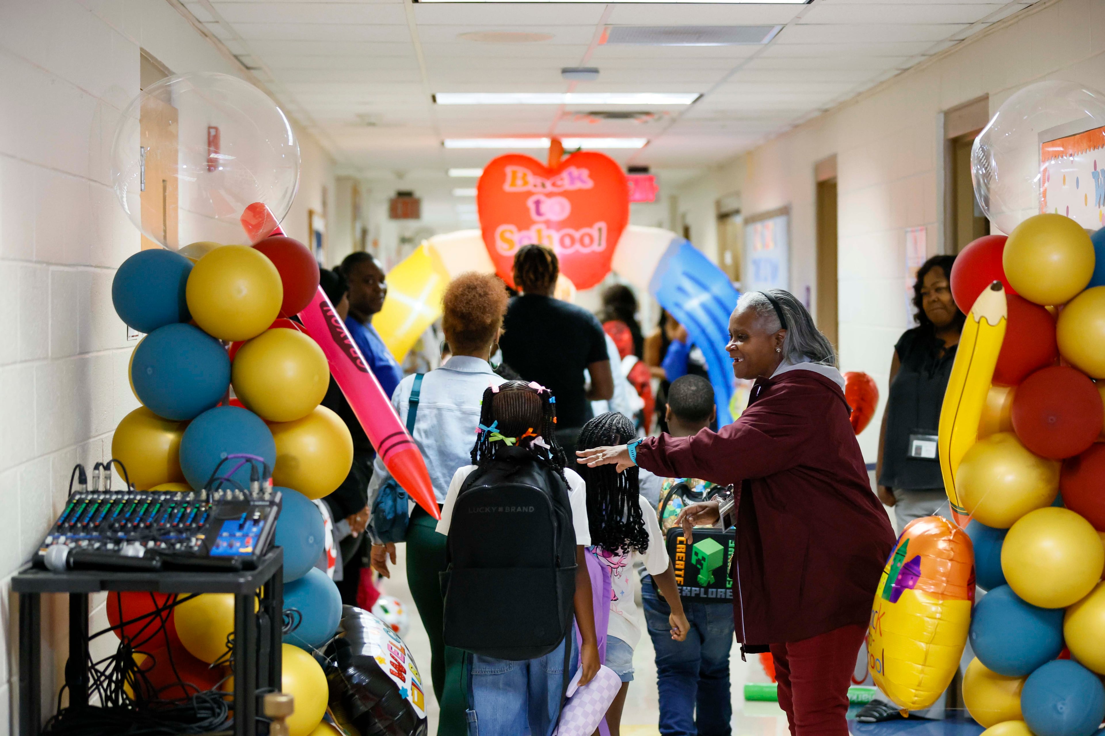 Hope-Hill Elementary School staff greet students on the first day of classes at on Monday. (Miguel Martinez/AJC)