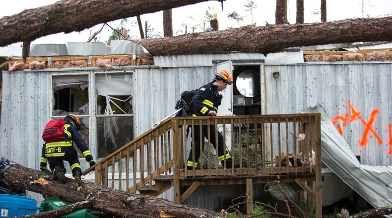 Rescue workers prepare to enter a mobile home Monday, Jan. 23, 2017, to search for survivors at Big Pine Estates that was damaged by a tornado, in Albany, Ga. Fire and rescue crews were searching through the debris Monday, looking for people who might have become trapped when the storm came through. (AP Photo/Branden Camp)
