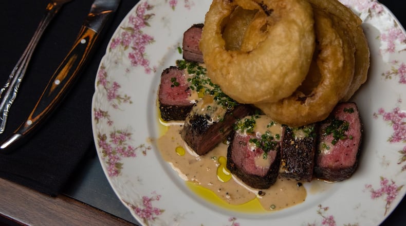 Tavern steak au poivre with onion rings at Golden Eagle, served on kitschy china befitting the restaurant’s theme. CONTRIBUTED BY HENRI HOLLIS