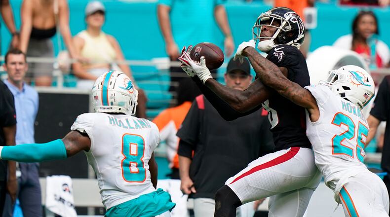 Falcons tight end Kyle Pitts (8) catches a pass between Miami Dolphins cornerback Xavien Howard (25) and free safety Jevon Holland (8) during the second half Sunday, Oct. 24, 2021, in Miami Gardens, Fla. (Wilfredo Lee/AP)