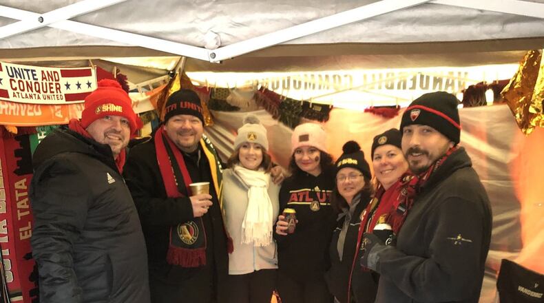 Kyle Yessa keeps warm with his tailgate crew at The Gulch before the Atlanta United game. (Photo: Carrie Teegardin/AJC)