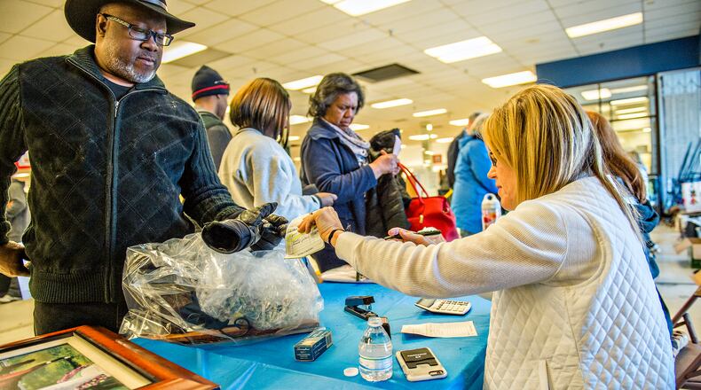 Rickey McCray (left) checks out with Gretchen Lehane during the 25th annual Sandy Springs Society Tossed Out Treasures sale at Marshall's Plaza in Sandy Springs in 2016. Proceeds from the sale support nonprofit organizations within the community. JONATHAN PHILLIPS / SPECIAL