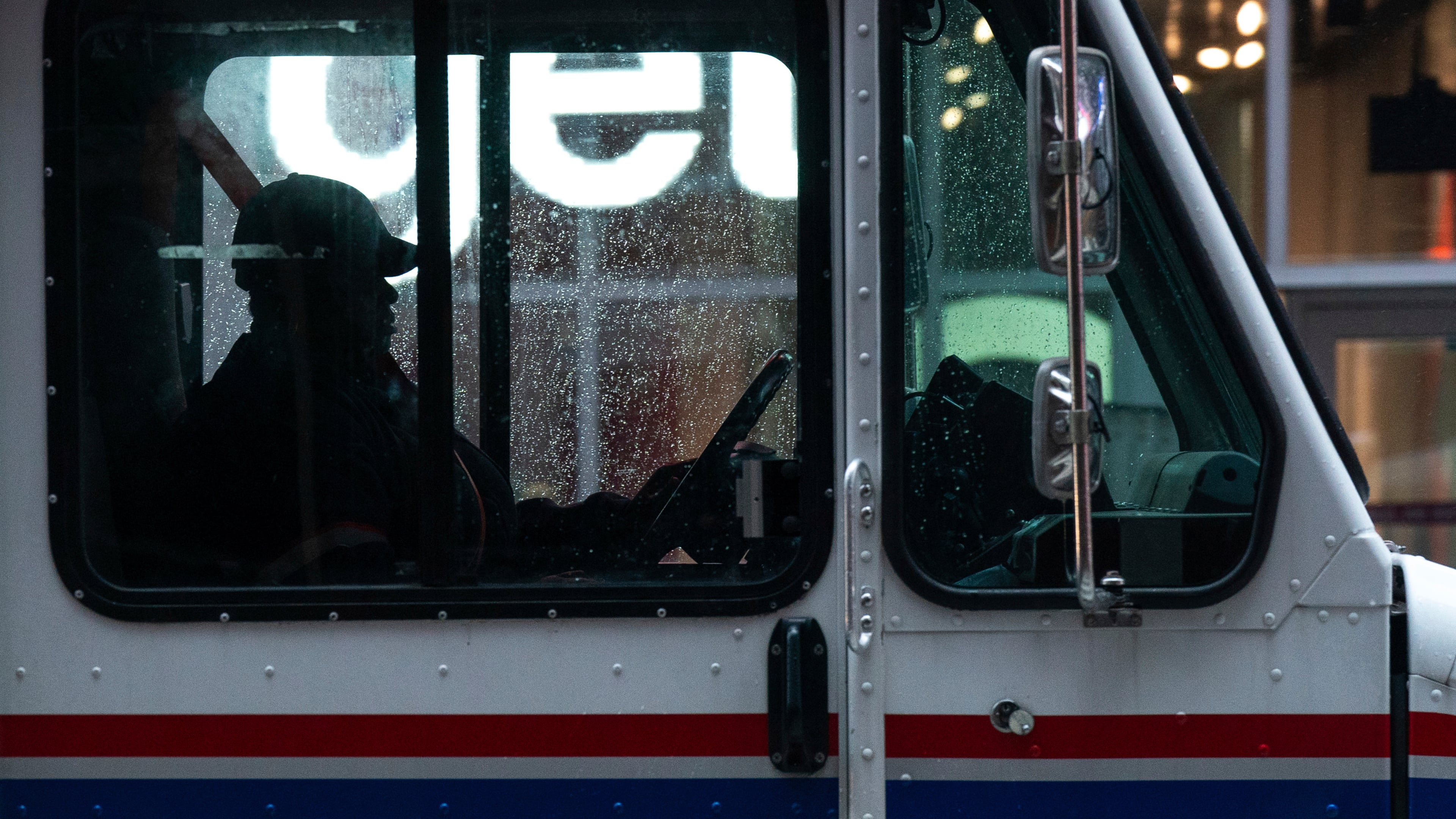 FILE - A United States Postal Service driver sits behind the wheel of a mail truck in Times Square, Nov. 21, 2024 in New York. (AP Photo/Adam Gray, File)