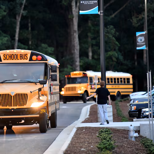 School buses arrived on the first day of school at Seckinger High School in Gwinnett County on Aug. 3, 2022. Gwinnett is one of several metro Atlanta school districts that are switching to remote learning on Monday. (Hyosub Shin/AJC)