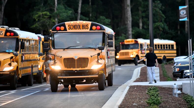 School buses arrived on the first day of school at Seckinger High School in Gwinnett County on Aug. 3, 2022. Gwinnett is one of several metro Atlanta school districts that are switching to remote learning on Monday. (Hyosub Shin/AJC)