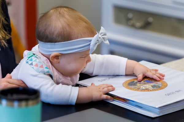 Grace Melton, 7-month-old, is held by her mother, Florida Rep. Fiona McFarland, R-Sarasota, while she touches a binder on her desk, Thursday, April 17, 2025, in Tallahassee, Fla. (AP Photo/Colin Hackley)