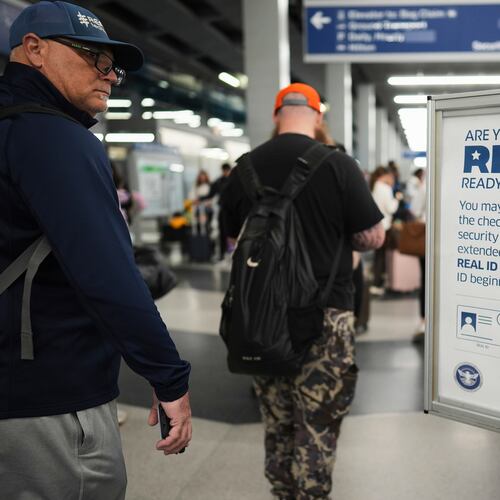 FILE - Travelers walk past a Real ID sign posted inside terminal 3 at O'Hare International Airport in Chicago, Friday, May 23, 2025. (AP Photo/Nam Y. Huh, File)