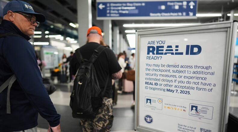 FILE - Travelers walk past a Real ID sign posted inside terminal 3 at O'Hare International Airport in Chicago, Friday, May 23, 2025. (AP Photo/Nam Y. Huh, File)