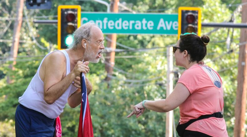 August 15, 2017 Atlanta: Confederate Flag runner Alan Keck (left) debates Grant Park resident Katie Kurumada (right) about the petition to change the name of Confederate Avenue on Tuesday, Aug. 15, 2017 on Boulevard. JOHN SPINK/JSPINK@AJC.COM