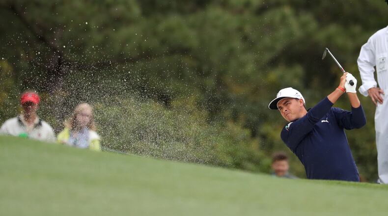 Rickie Fowler hits from the fairway bunker on No. 1 during the third round of the Masters Tournament on Saturday, April 7, 2018, at Augusta National Golf Club. PHOTO / JASON GETZ