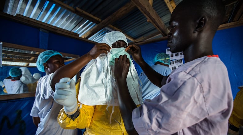 The following photo is in the David J. Sencer CDC Museum’s Ebola exhibit: A Liberian nurse prepares to draw blood from patients at the Ebola Treatment Unit. CONTRIBUTED BY MORGANA WINGARD, COURTESY OF USAID