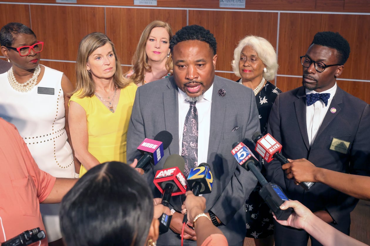 Devon Horton talks with members of the media after the DeKalb County Board of Education hired him for the superintendent position at the DeKalb County Administrative Center on April 19, 2023, in Stone Mountain, Ga. Behind Horton are five of the six board members who voted yes for him. (Jason Getz / AJC)