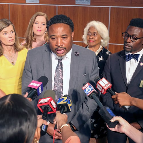 Devon Horton talks with members of the media after the DeKalb County Board of Education hired him for the superintendent position at the DeKalb County Administrative Center on April 19, 2023, in Stone Mountain, Ga. Behind Horton are five of the six board members who voted yes for him. (Jason Getz / AJC)