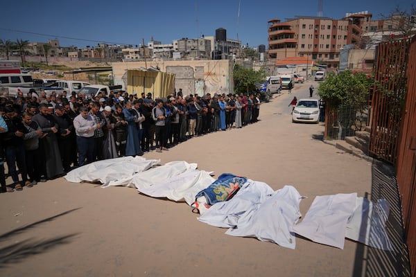 Mourners pray over the bodies of Jehad Abu Sultan, his wife Amal, their three children Dana, Hasan, and Habeba, along with other relatives and a neighbor, all killed during an Israeli army strike in Khan Younis, southern Gaza Strip, on the first day of the Muslim holiday of Eid, Sunday, March 30, 2025. (AP Photo/Abdel Kareem Hana)