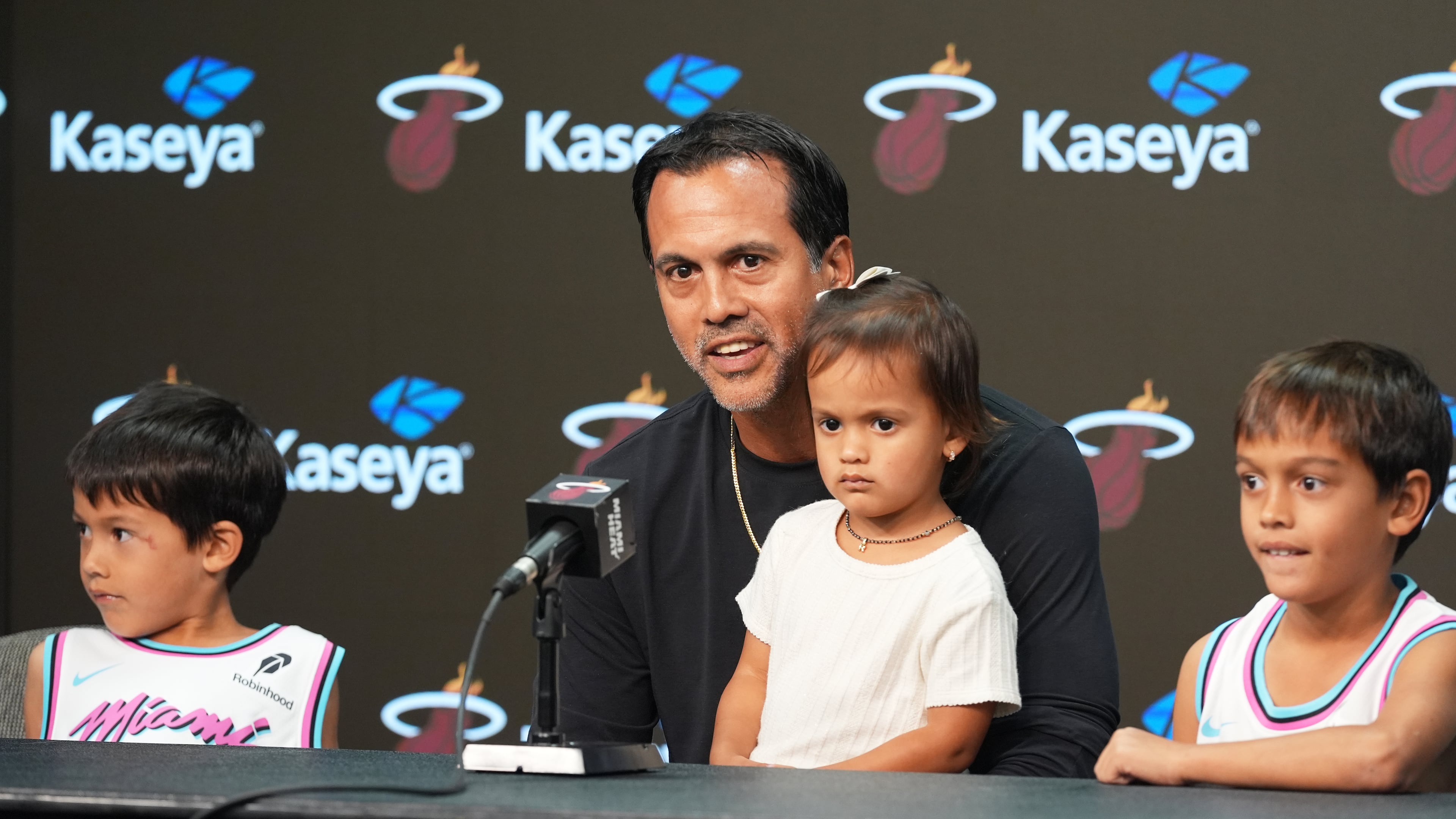 Miami Heat head coach Erik Spoelstra sits with his children as he talks about a fire that destroyed his home before an NBA Cup basketball game against the Charlotte Hornets Friday, Nov. 7, 2025, in Miami. (AP Photo/Marta Lavandier)
