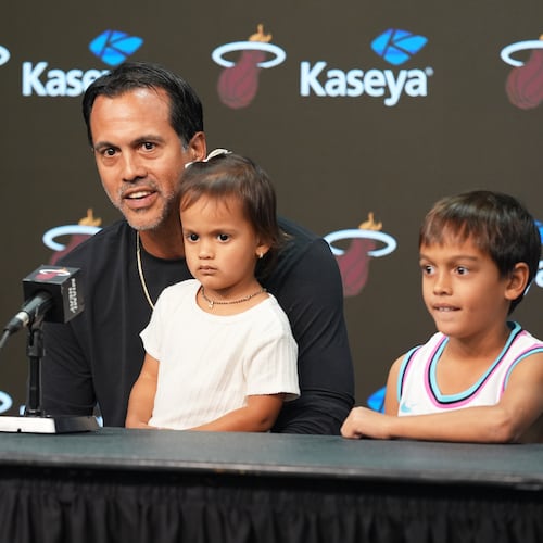 Miami Heat head coach Erik Spoelstra sits with his children as he talks about a fire that destroyed his home before an NBA Cup basketball game against the Charlotte Hornets Friday, Nov. 7, 2025, in Miami. (AP Photo/Marta Lavandier)