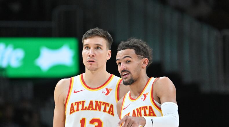Atlanta Hawks guard Trae Young (11) confers with Atlanta Hawks guard Bogdan Bogdanovic (13) during the fourth quarter in an NBA basketball game at State Farm Arena, Saturday, February 3, 2024, in Atlanta. Atlanta Hawks won 141-134 in overtime. (Hyosub Shin / Hyosub.Shin@ajc.com)