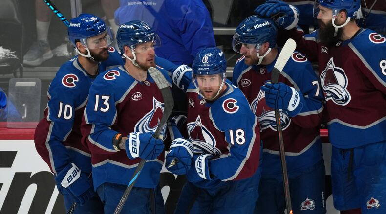 Colorado Avalanche center Jack Drury, center, is congratulated by, from left, center Nicolas Roy, right wing Valeri Nichushkin, and defensemen Devon Toews and Brent Burns in the third period of Game 5 of an NHL Stanley Cup hockey second-round playoff series against the Minnesota Wild Wednesday, May 13, 2026, in Denver. (AP Photo/David Zalubowski)