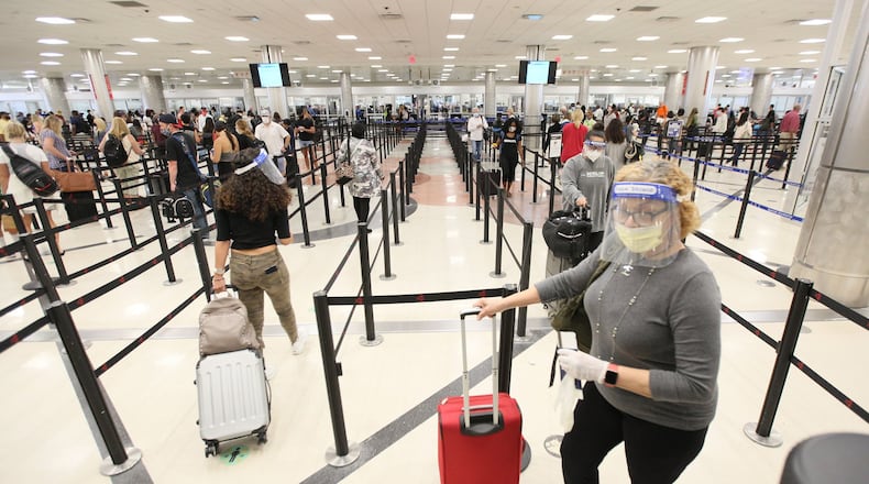 Passengers with face masks and shields wait in the Security Checkpoint Line at the South Terminal of the Atlanta Hartsfield-Jackson International Airport.Tuesday, June 23, 2020. Miguel Martinez for The Atlanta Journal-Constitution