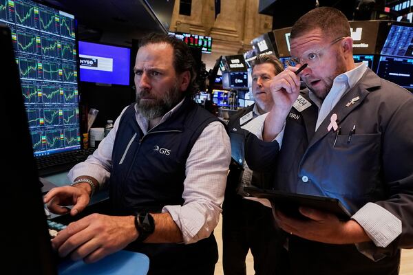 Specialist Michel Pistillo, left, works with traders James Matthews, center, and Ryan Falvey on the floor of the New York Stock Exchange, Wednesday, April 23, 2025. (AP Photo/Richard Drew)