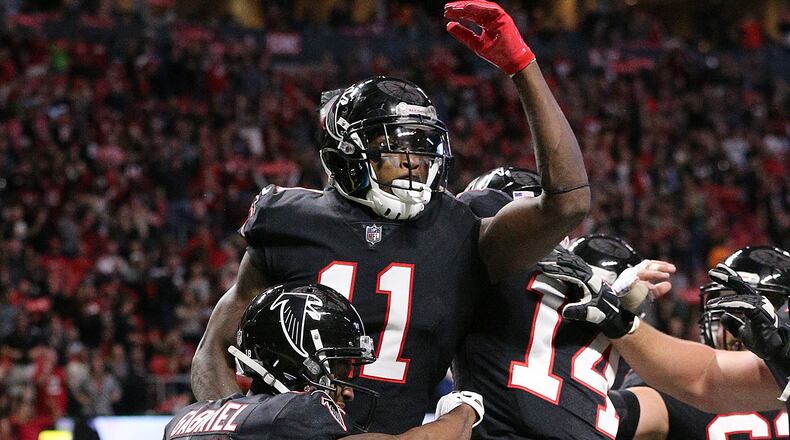 Falcons wide receiver Julio Jones celebrates his touchdown catch with Taylor Gabriel and Justin Hardy on a pass from wide receiver Mohamed Sanu during a trick play to take a 10-3 lead during the second quarter in a NFL football game on Sunday, November 26, 2017, in Atlanta. Jones caught two touchdown passes in the second quarter. Curtis Compton/ccompton@ajc.com