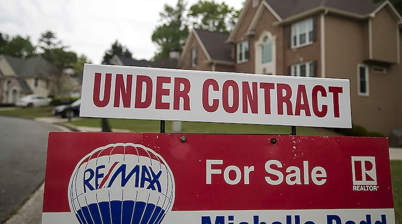 A home for sale sign is displayed in the yard of Lois and John Schmitt at their home in Powder Springs, Tuesday, April 7, 2020. The Schmitts are downsizing their belongings and are finding it hard to get rid of bigger items, like furniture. They said donation sights have stopped taking furniture amid the COVID-19 world pandemic. Their current closing date is April 21.