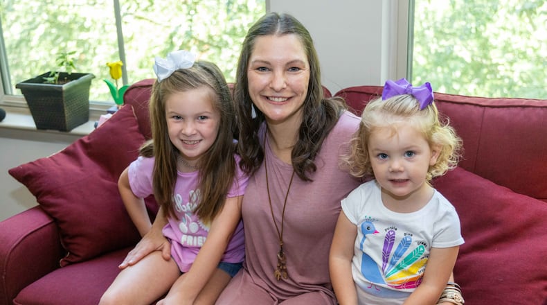Emberly Burns, 7, (from left) her mother Amber and sister Amelia,2, sit together on the couch in their apartment in Atlanta. Burns, a Caringworks client, is a single mother who has faced many trials including drug addiction, an abusive relationship and homelessness. PHIL SKINNER FOR THE ATLANTA JOURNAL-CONSTITUTION