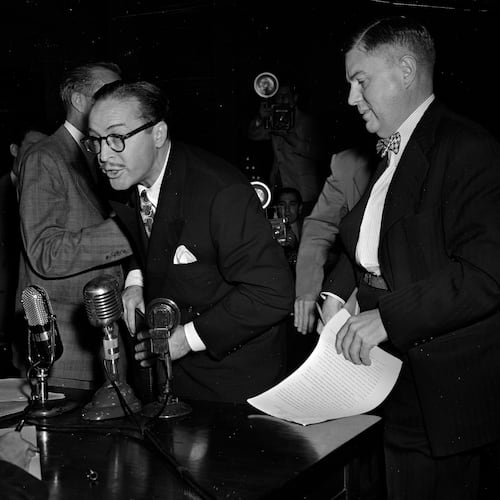 FILE - Dalton Trumbo, left, Hollywood screenwriter, shouts from the witness stand as he tries to make a statement before the House Un-American Activities Committee, Oct. 28, 1947, in Washington. At right is his attorney Robert Kenny. Trumbo was excused from further testimony when he refused to state whether he is or has been a communist. (AP Photo/Byron Rollins, File)