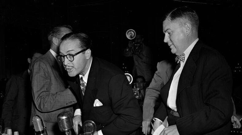 FILE - Dalton Trumbo, left, Hollywood screenwriter, shouts from the witness stand as he tries to make a statement before the House Un-American Activities Committee, Oct. 28, 1947, in Washington. At right is his attorney Robert Kenny. Trumbo was excused from further testimony when he refused to state whether he is or has been a communist. (AP Photo/Byron Rollins, File)