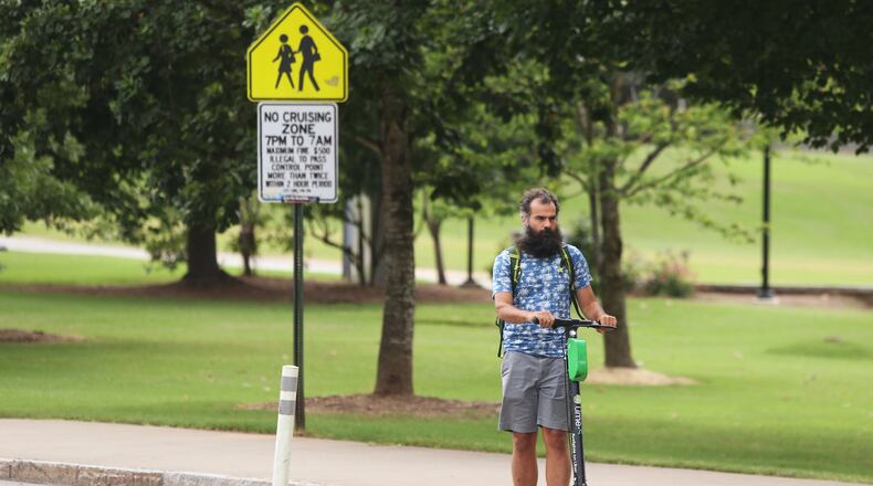 A man rides a scooter by Piedmont Park in Atlanta on Wednesday, July 18, 2019.Christina Matacotta/Christina.Matacotta@ajc.com