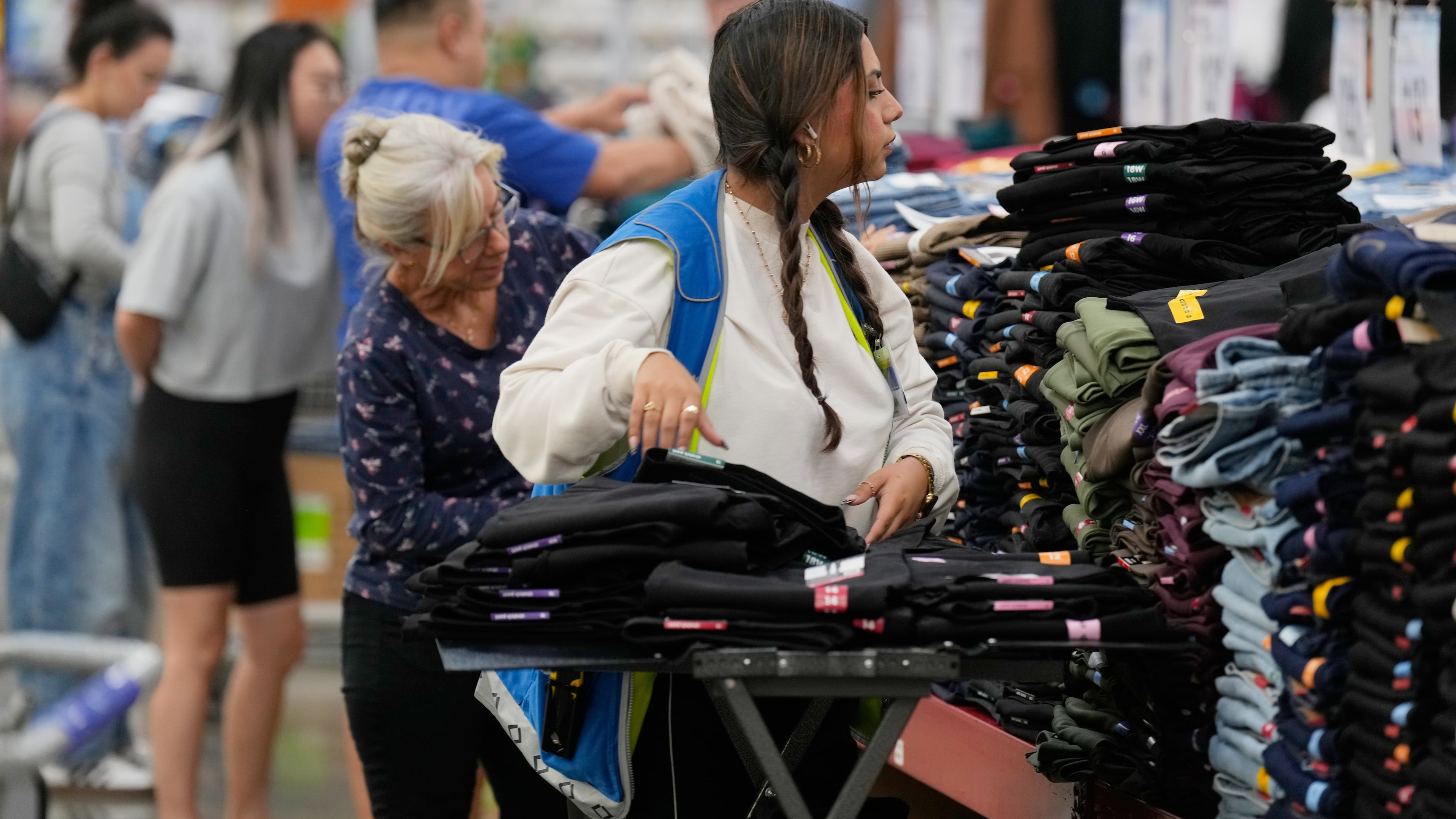 A worker stocks a display of clothing at a Sam's Club, Wednesday, Sept. 24, 2025, in Bentonville, Ark. (AP Photo/Charlie Riedel)