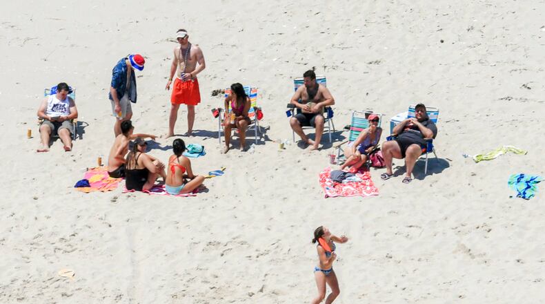 In this Sunday, July 2, 2017, photo, New Jersey Gov. Chris Christie, right, uses the beach with his family and friends at the governor's summer house at Island Beach State Park in New Jersey. Christie is defending his use of the beach, closed to the public during New Jersey's government shutdown, saying he had previously announced his vacation plans and the media had simply "caught a politician keeping his word." (Andrew Mills/NJ Advance Media via AP)