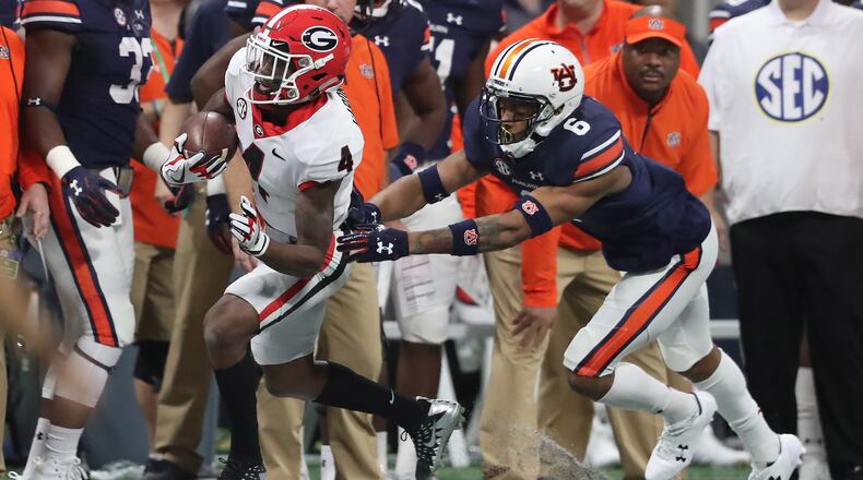 Georgia Bulldogs wide receiver Mecole Hardman (4) makes a 19-yard pickup and a first down against Auburn Tigers defensive back Carlton Davis (6) during the first half of the SEC Football Championship at Mercedes-Benz Stadium, December 2, 2017, in Atlanta. Curtis Compton / ccompton@ajc.com