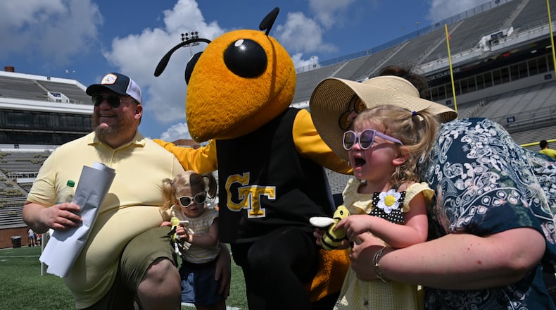 Nezzy Usry (right), 2, cries as she poses with Buzz during Georgia Tech football’s annual Fan Day at Bobby Dodd Stadium, Saturday, August 5, 2023, in Atlanta. First Saturday on The Flats presented by Georgia’s Own Credit Union – Georgia Tech football’s annual Fan Day event – featured a plethora of other interactive on-field activities for the whole family, including the opportunity to run out of the Georgia Tech tunnel onto the field like the Yellow Jackets do on gameday, a football toss, ladder drills, combine and tailgate games, an agility course, field goal kicking, a uniform station, 360-degree photo booth and more. (Hyosub Shin / Hyosub.Shin@ajc.com)
