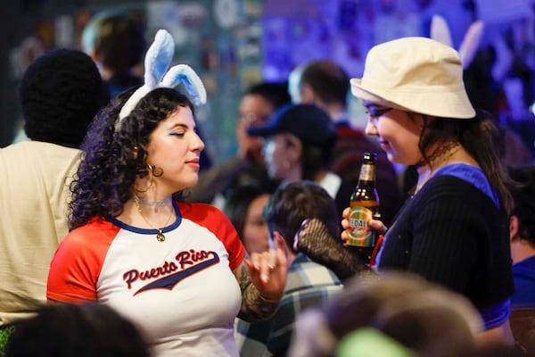 Malia Graciani, wearing bunny ears, dances to Latin music at the Debí Tirar Más Football event, a Bad Bunny Super Bowl halftime watch party and fundraiser for Casa Alterna, at Thinking Man Tavern in Decatur on Sunday, Feb. 8, 2026. (Miguel Martinez/AJC)