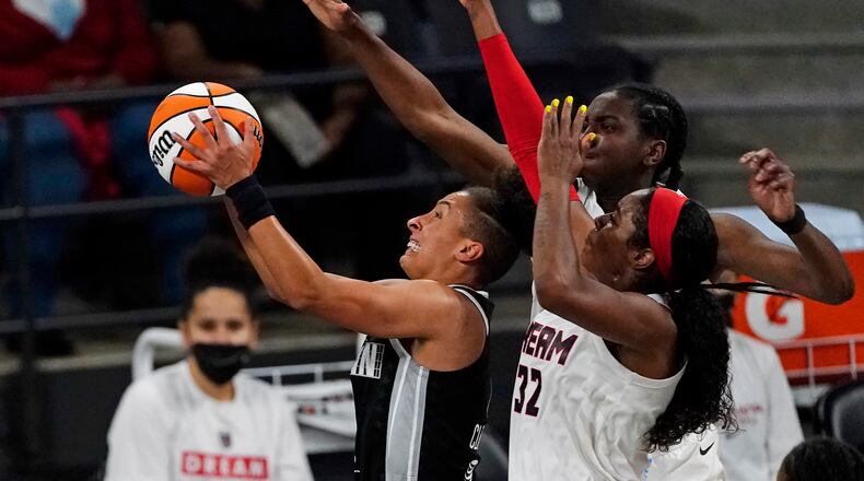 Minnesota's Layshia Clarendon gets past the Atlanta Dream's Elizabeth Williams and Cheyenne Parker. (AP Photo/John Bazemore)