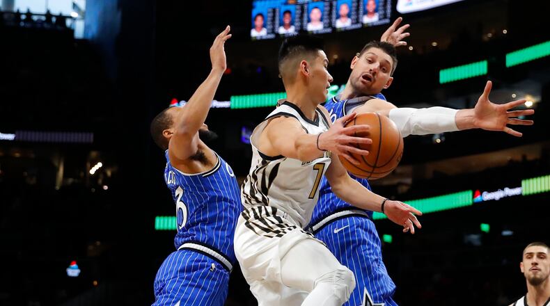 Atlanta Hawks guard Jeremy Lin (7) passes around Orlando Magic center Nikola Vucevic (9) in the first half Monday, Jan. 21, 2019, in Atlanta.