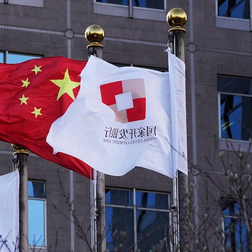 FILE - Flags of the China Development Bank are flown near a Chinese flag outside a subsidiary branch office of the Bank in Beijing, Jan. 8, 2021. (AP Photo/Ng Han Guan, File)
