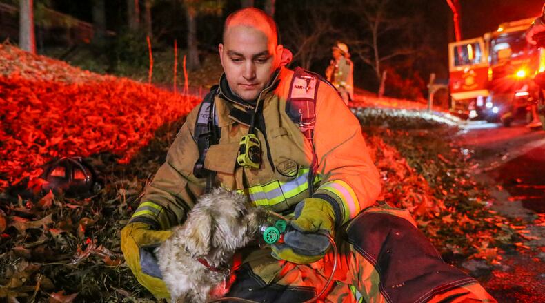 December 20, 2016 Atlanta: Atlanta firefighter, Andrew Morgan of Truck 1 gives oxygen to a dog rescued from a burning house after Atlanta firefighters rescued a man and the dog from the house early Tuesday, Dec. 20, 2016 in northwest Atlanta. Firefighters went to the home in the 2800 block of Baker Ridge Drive and tried to enter through the front door, Atlanta fire Capt. Kelen Evans told The Atlanta Journal-Constitution. A lieutenant went to the back of the home and found the man near a door. "She alerted us," Evans said. "We got the door open and pulled him out." Emergency workers administered CPR. The man's condition was not known. "But he was breathing when we brought him out," Evans said. "That's about all I can tell you." The blaze damaged a front room, Atlanta fire battalion Chief Darrel Mason said. "We have fire investigators on the scene now, so we can't give any indication of what might have caused the issue," Mason said. No other details were released. JOHN SPINK /JSPINK@AJC.COM