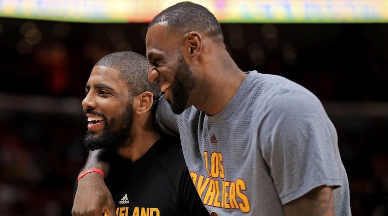 Kyrie Irving and LeBron James of the Cleveland Cavaliers laugh during a game against the Miami Heat.