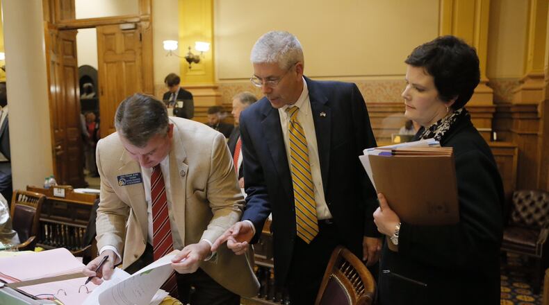 (Left to right) state Sen. Frank Ginn, R-Danielsville, state Sen. Bill Heath, R-Bremen and state Rep. Mandi Ballinger, R-Canton, sign a conference committee report on Georgia’s “campus carry” gun bill. BOB ANDRES / BANDRES@AJC.COM
