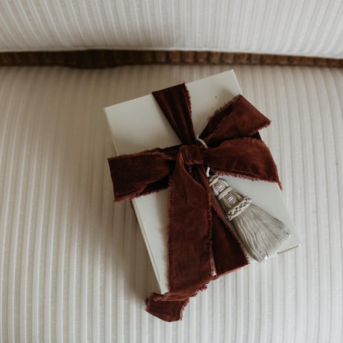 A gift wrapped with Page House Studio’s sculptural Tassel Ornament — a handcrafted piece that doubles as a keepsake and one of the Atlanta design studio’s most elevated holiday offerings. (Courtesy of Anna Howard)