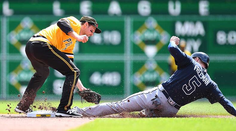Freddie Freeman safely steals second base in front of the Pirates' Phil Gosselin during Sunday's game.