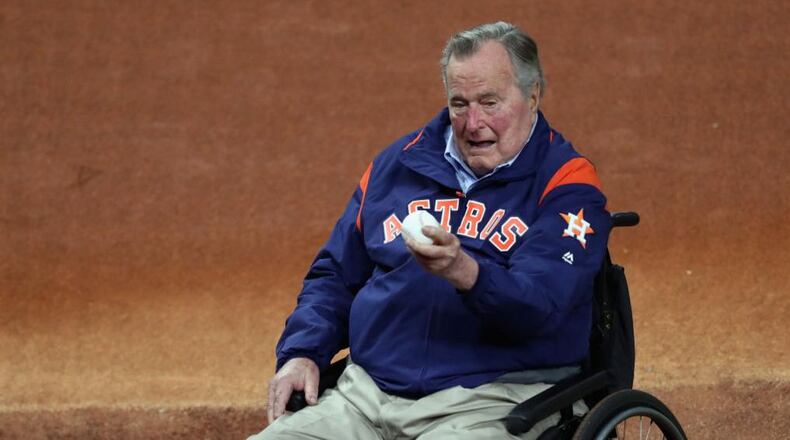 George H.W. Bush examines the baseball before Game 5 of the 2017 World Series at Minute Maid Park in Houston.