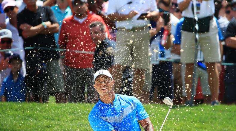Tiger Woods supplies one of the standard blast-out-of-the-bunker photos Thursday during the first round of the BMW Championship. (Photo by Andrew Redington/Getty Images)