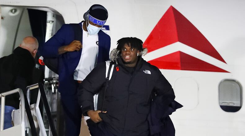 Georgia defensive tackle Jordan Davis leaves the plane in the frigid cold during the College Football Playoff National Championship team arrivals at Indianapolis Airport on Friday, Jan. 7, 2022, in Indianapolis. “Curtis Compton / Curtis.Compton@ajc.com”`