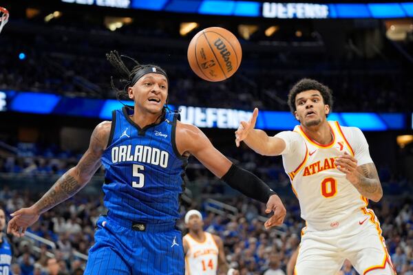Orlando Magic forward Paolo Banchero (5) and Atlanta Hawks forward Dominick Barlow (0) go after a rebound during the first half of an NBA play-in tournament basketball game, Tuesday, April 15, 2025, in Orlando, Fla. (AP Photo/John Raoux)