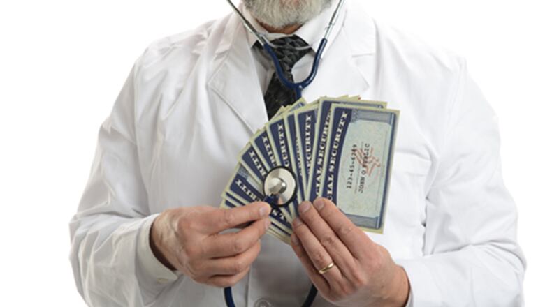 Doctor with esthetoscope and social security cards (Dreamstime/TNS)