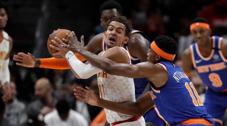 Atlanta Hawks guard Trae Young (11) is covered by New York Knicks guard Frank Ntilikina (11) during the second half Wednesday, March 11, 2020, at State Farm Arena in Atlanta.