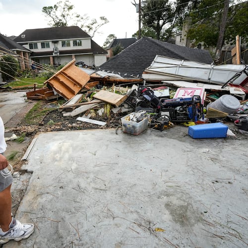 Guillermo Vargas surveys damage to his home, where his garage was swept off its foundation, while cleaning up storm damage after severe weather hit in the Memorial Northwest subdivision, in Spring, Texas, Monday, Nov. 24, 2025. (Brett Coomer/Houston Chronicle via AP)